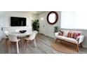 Well-lit living area with dining table, sofa and flat-screen tv at 8627 Santa Fe Dr, Thornton, CO 80260