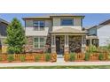 Charming two-story home featuring a stone facade, covered porch, and a fenced front yard at 764 N Quatar St, Aurora, CO 80018