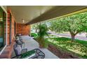 Relaxing covered front porch with comfortable seating and views of the landscaped yard at 6918 E Long Ave, Centennial, CO 80112