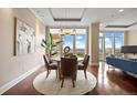 Open-concept dining area with hardwood floors, bright windows, modern lighting, and easy access to the living room at 7600 Landmark Way # 1215, Greenwood Village, CO 80111