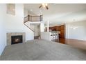 Open concept living room with fireplace, stairs, and kitchen view at 7662 Bristolwood Dr, Castle Pines, CO 80108