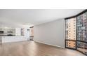 Bright living room with light hardwood floors and large windows showcasing city views at 1625 Larimer St # 1001, Denver, CO 80202