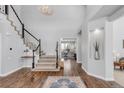 Grand foyer with hardwood floors, a staircase, and a view into a bright and airy office at 445 Brendon Ct, Castle Pines, CO 80108