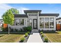 Contemporary home featuring black trim, modern windows, walkway, and manicured front yard at 4752 Eliot St, Denver, CO 80211