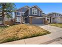 Charming two-story home featuring blue siding, brick accents, an attached two-car garage, and a well-maintained front yard at 17018 Carr Ave, Parker, CO 80134
