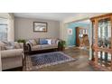 Inviting living room featuring stylish furnishings, a decorative mirror and beautiful wood floors at 17018 Carr Ave, Parker, CO 80134