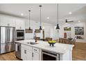 Bright open kitchen features stainless steel appliances, island, and views of a dining area at 42988 Colonial Trl, Elizabeth, CO 80107