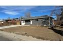 Single-story home with a freshly poured concrete driveway leading to a one car garage at 121 Joan Dr, Denver, CO 80221