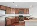 This modern kitchen features stainless steel appliances, granite counters, and wood cabinetry and flooring at 100 Park Ave # 907, Denver, CO 80205