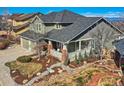 Charming two-story home boasts a welcoming front porch, landscaped yard, and inviting curb appeal at 10726 Amesbury Way, Highlands Ranch, CO 80126