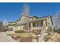 Beautiful home features a spacious two-car garage, a covered front porch, and manicured landscaping at 10726 Amesbury Way, Highlands Ranch, CO 80126