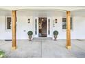 Inviting front porch featuring decorative columns, elegant lighting, and a clear view into the home at 3756 S Chase St, Denver, CO 80235