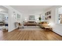 Bright living room featuring hardwood floors, neutral paint, stylish furniture, and plenty of natural light at 3756 S Chase St, Denver, CO 80235