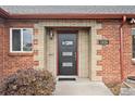 A close up of the brick facade and front door entrance of this cozy home at 2835 N Monaco Pkwy, Denver, CO 80207