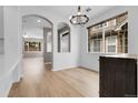 Bright dining room with wood floors, archways, and modern chandelier at 1409 Carlyle Park Cir, Highlands Ranch, CO 80129