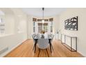 Bright dining room with hardwood floors, modern lighting, and large windows showcasing the backyard at 6274 S Iola Ct, Englewood, CO 80111