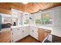 Well-lit kitchen features a window over the sink, plus painted brick backsplash and wood ceiling at 3756 S Mission Pkwy, Aurora, CO 80013