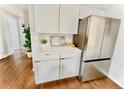 This kitchen features white cabinets and stainless steel refrigerator, offering a sleek design at 1853 S Urban Way, Lakewood, CO 80228
