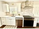 Bright kitchen features stainless steel appliances, tile backsplash, and white cabinets at 1853 S Urban Way, Lakewood, CO 80228