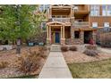 Home entrance with a stone facade, covered porch, and well-kept front yard at 5574 W 72Nd Dr, Arvada, CO 80003