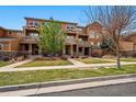 Inviting townhomes with stone accents, private balconies, and well-maintained front yards at 5574 W 72Nd Dr, Arvada, CO 80003