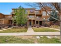 Townhouse complex showcasing multiple units with covered entrances and manicured lawns at 5574 W 72Nd Dr, Arvada, CO 80003