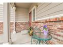 Cozy front patio with a small table and chairs, perfect for relaxing outdoors at 14944 E Archer Cir, Aurora, CO 80012