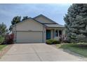 Inviting home exterior showcasing a well-maintained lawn, mature trees, and a charming blue front door at 9784 W Euclid Dr, Littleton, CO 80123