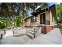 Classic home with brick accents, concrete steps and covered porch in a mature treed setting at 1243 Monroe St, Denver, CO 80206