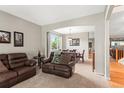 Cozy living room featuring comfortable leather sofas and an open archway into the dining room at 9162 W Unser Ave, Littleton, CO 80128