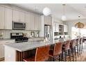 Modern kitchen with granite countertops, stainless steel appliances, and leather barstools at 1576 W Maple Ave, Denver, CO 80223