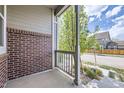 Cozy front porch featuring brick accents and a view of the quiet street and nearby home at 14176 Jackson St, Thornton, CO 80602