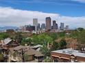 Scenic daytime cityscape of Denver with mountain views, lush trees, and building rooftops at 1085 N Lafayette St # 704, Denver, CO 80218
