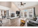 Bright living room with a cozy fireplace, and floor-to-ceiling windows dressed with elegant curtains at 13421 Humboldt Way, Thornton, CO 80241