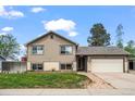 Inviting two-story home with attached garage, manicured lawn, and charming brick accents at 5338 Granby St, Denver, CO 80239