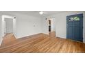 Entry to an open concept living area with hardwood floors and a blue front door at 3368 S Corona St, Englewood, CO 80113