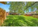 Sprawling green backyard with large trees and fences on the perimeter at 7902 Meade St # A10, Westminster, CO 80030
