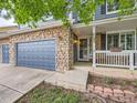 Charming front entrance with brick accents, well-maintained landscaping, and a two-car garage at 5163 Apache Creek Rd, Castle Rock, CO 80109