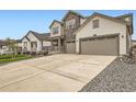 Long, wide driveway leading up to a three-car garage of a home with a charming front porch and stone accents at 1403 Hart Ln, Elizabeth, CO 80107