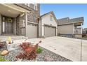 Close-up of the home's exterior, displaying the front door, stone accents, and a well-kept front yard at 1403 Hart Ln, Elizabeth, CO 80107