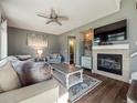 Cozy living room with a fireplace, plush seating, and modern decor at 10657 Cherrybrook Cir, Highlands Ranch, CO 80126
