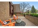 Inviting outdoor patio with comfortable seating, a modern fire pit, and attractive brick accents at 4032 S Olive St, Denver, CO 80237