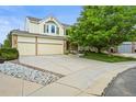Charming two-story home with a three-car garage, featuring a well-manicured lawn and mature trees at 6364 S Walden Ct, Aurora, CO 80016