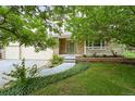 Inviting home with a covered porch, complemented by a beautifully landscaped front yard and mature trees at 6364 S Walden Ct, Aurora, CO 80016