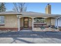 Charming front porch detail on a brick home with a cozy sitting area and beautiful plants at 4585 Garrison St, Wheat Ridge, CO 80033