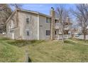 A charming condo with a stone chimney, two balconies, a well-kept lawn, and stairs to the upper level at 14192 E Colorado Dr # 102, Aurora, CO 80012