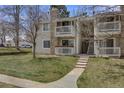 A charming condo with a stone chimney, two balconies, a well-kept lawn, and stairs to the upper level at 14192 E Colorado Dr # 102, Aurora, CO 80012