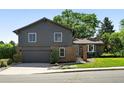 Charming two-story home featuring a well-manicured lawn, mature trees, and a covered front entrance at 5616 S Kenton Ct, Englewood, CO 80111