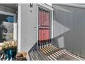 Townhouse entrance featuring a red security door, wood siding, and a welcome mat at 6600 E Mississippi Ave # 7, Denver, CO 80224