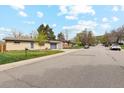 Attractive single-story brick home featuring a well-manicured lawn, mature trees and attached garage at 320 Orion St, Golden, CO 80401